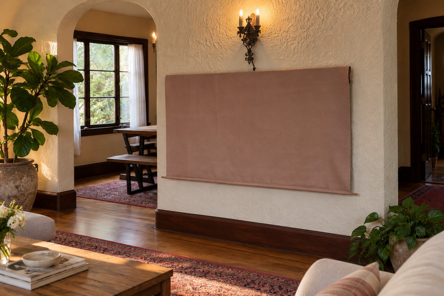 Wide living room view with arched doorways, plants, a patterned rug and the dusty rose television cover